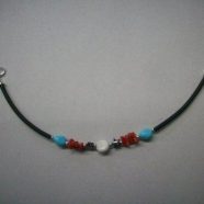 Bracciale in caucciu’, pasta di turchese, corallo , stelline di ematite ed opercolo